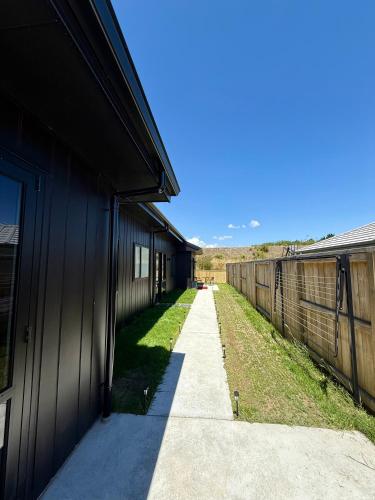 a walkway between two buildings next to a fence at Luxury Living in Taupo