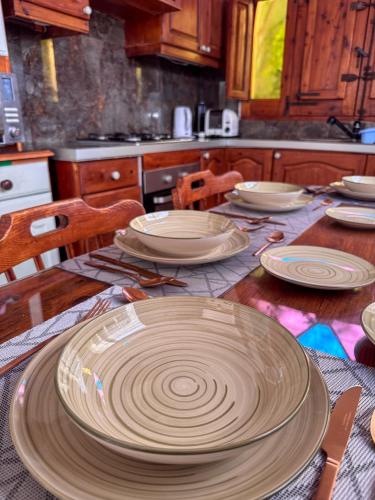 a wooden table with plates on it in a kitchen at Tal Jordan Complex in Għarb