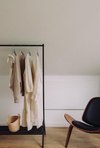 a rack of clothes in a room with a chair at BialogoraChill11C in Białogóra