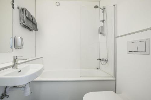 a white bathroom with a sink and a shower at Hardangerfjord Hotel in Øystese