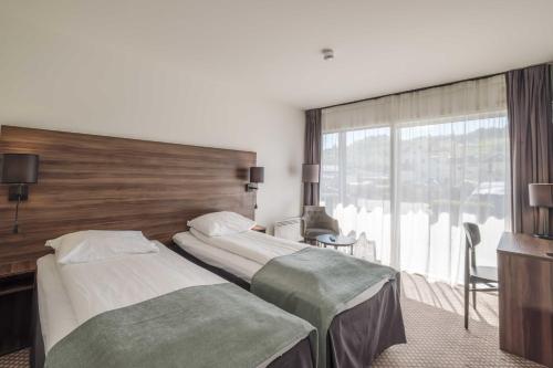 a hotel room with two beds and a large window at Hardangerfjord Hotel in Øystese