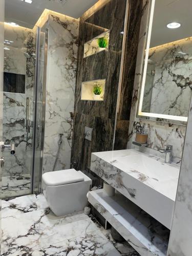a bathroom with a toilet and a sink and a shower at Designer 1BR I Golf View I Comfortably Sleeps 4 in Dubai