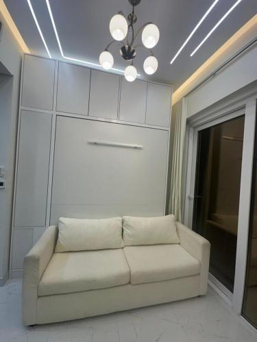a white couch in a living room with a ceiling at Designer 1BR I Golf View I Comfortably Sleeps 4 in Dubai
