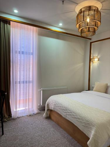 a bedroom with a bed and a large window at Palm Tbilisi Boutique Hotel in Tbilisi City