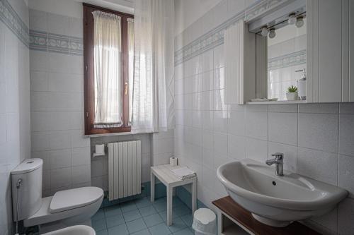 a white bathroom with a sink and a toilet at Giada Palace Apartments & Pool - Giada Palace Group in Lucca