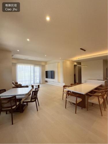 a living room with tables and chairs and a kitchen at 樵築包棟泳池民宿 唱歌電動麻將烤肉 2025年6月全新裝潢 in Yuanshan