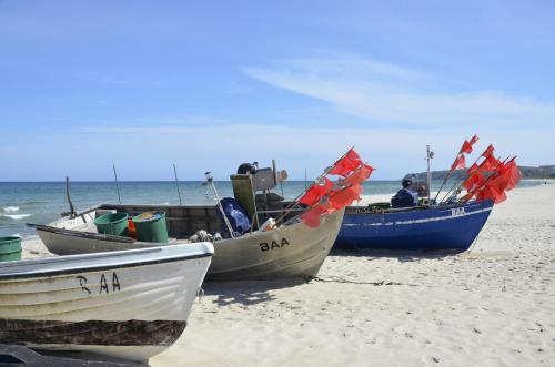 three boats sitting on a sandy beach near the ocean at Inselzeit Comfort Suites SELLIN in Ostseebad Sellin