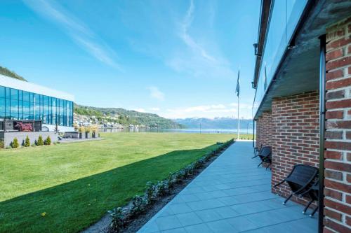 a walkway next to a building with a grass field at Hardangerfjord Hotel in Øystese