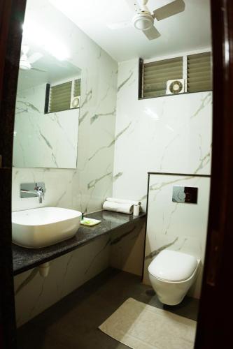 a bathroom with a sink and a toilet and a mirror at hotel sandhu palace in Jodhpur