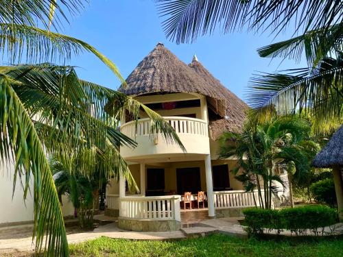ディアニ・ビーチにあるEnchanting 3bed Villa with Ac &poolの茅葺き屋根の家