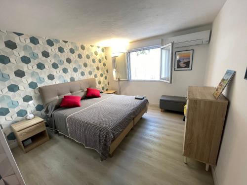 a bedroom with a bed with red pillows on it at FREJUS port et base nature in Fréjus