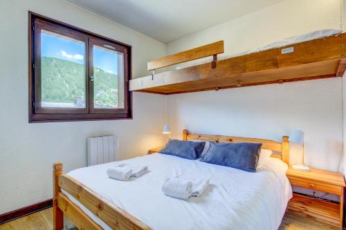 une chambre avec un lit avec deux oreillers dessus dans l'établissement Troïka 3, à Morzine