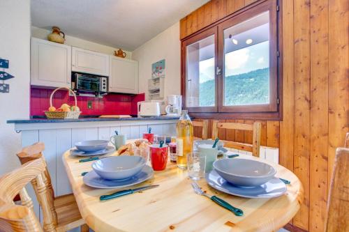 - une cuisine avec une table en bois et de la vaisselle dans l'établissement Troïka 3, à Morzine