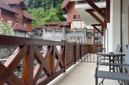 a balcony with a table and chairs overlooking a river at PENTA by Alfinio in Sinaia