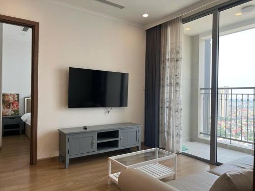 a living room with a flat screen tv on a wall at Chuỗi căn hộ dịch vụ Vinhomes Gardenia Mỹ Đình in Hanoi