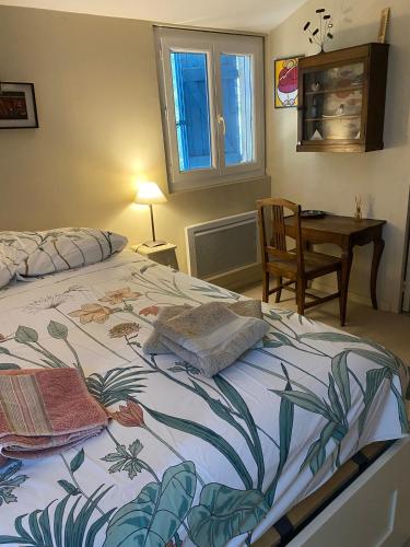 une chambre avec un lit, un bureau et une fenêtre dans l'établissement Joli Mas au bord de l'Etang de Thau, à Marseillan