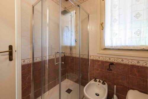 a bathroom with a shower and a toilet and a sink at Villa dei Licheni by MMega in Punta Ala