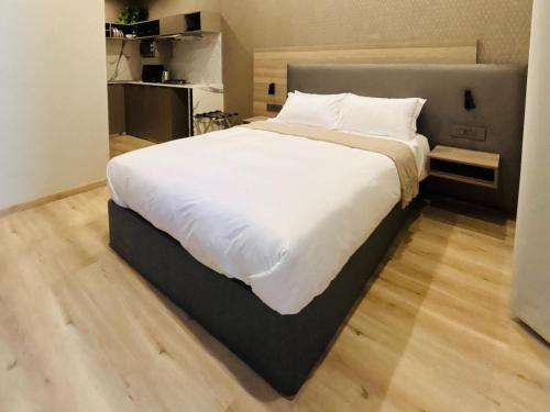 a large white bed in a bedroom with a wooden floor at The Symbol in Fourways