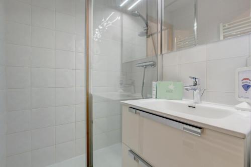 une salle de bain blanche avec un lavabo et une douche dans l'établissement Ranfolly 10, à Morzine