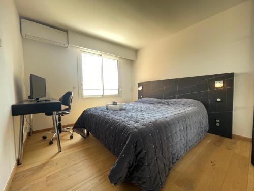une chambre avec un lit, un bureau et un ordinateur dans l'établissement Grand-Duc Résidence avec piscine - 2 pièces, à Mandelieu-la-Napoule