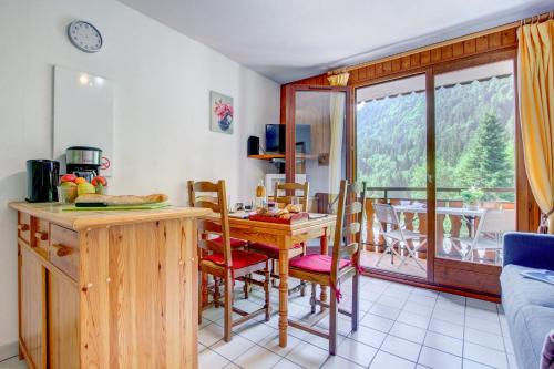 une cuisine et une salle à manger avec une table et un balcon dans l'établissement Ranfolly 10, à Morzine