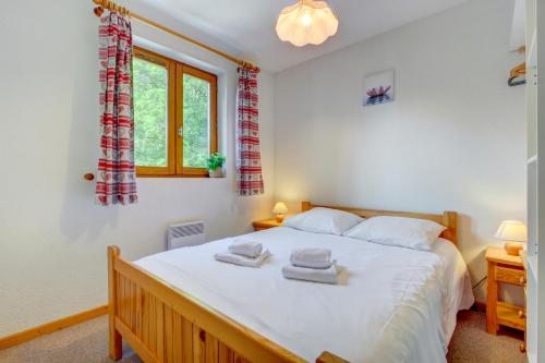 une chambre avec un grand lit blanc avec des serviettes dessus dans l'établissement Ranfolly 10, à Morzine