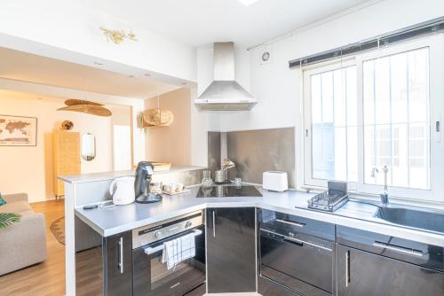 une cuisine avec un évier et un plan de travail dans l'établissement L'Escale Havraise - Plage à 500m, au Havre