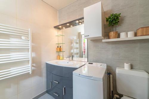 une salle de bain avec un lavabo, des toilettes et un miroir dans l'établissement L'Escale Havraise - Plage à 500m, au Havre