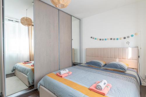 - une chambre avec 2 serviettes sur un lit et un miroir dans l'établissement L'Escale Havraise - Plage à 500m, au Havre