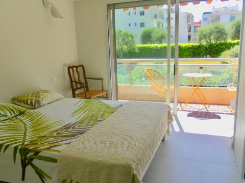 une chambre avec deux lits et une grande fenêtre dans l'établissement 2 pièces nice terrasse cosy, à Nice
