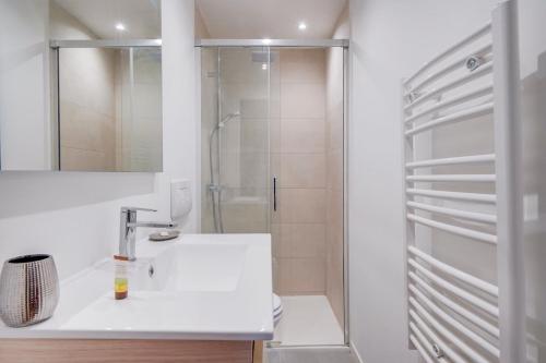 une salle de bain blanche avec un lavabo et une douche dans l'établissement Cozy duplex - Heart of Chartrons, à Bordeaux