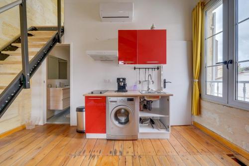 une cuisine avec une machine à laver dans une pièce dans l'établissement Cozy duplex - Heart of Chartrons, à Bordeaux