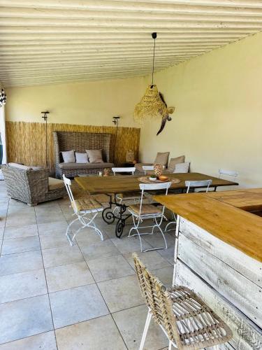- un salon avec des tables, des chaises et un canapé dans l'établissement Les Lodges de l'Etang, à Roquebrune-sur Argens