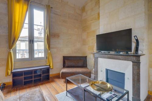 un salon avec une cheminée et une télévision dans l'établissement Cozy duplex - Heart of Chartrons, à Bordeaux