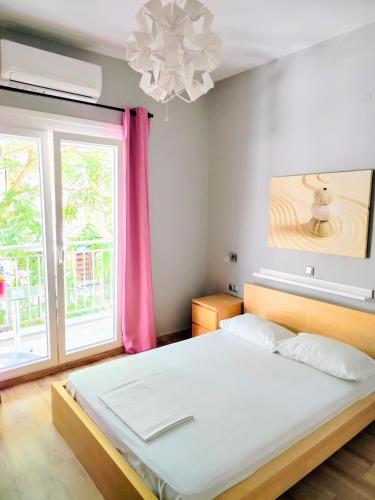 a bedroom with a large bed with a pink curtain at Hotel Europa - Family and Senior Friendly in Kavala