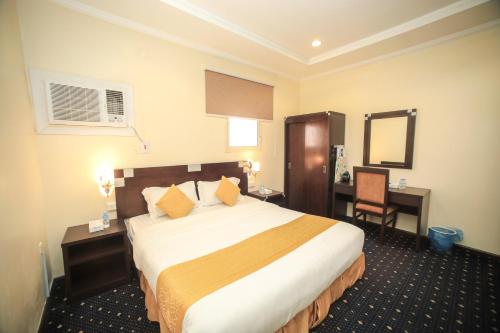 a hotel room with a large bed and a desk at توارن للشقق المخدومة - اقتصادي in Hail