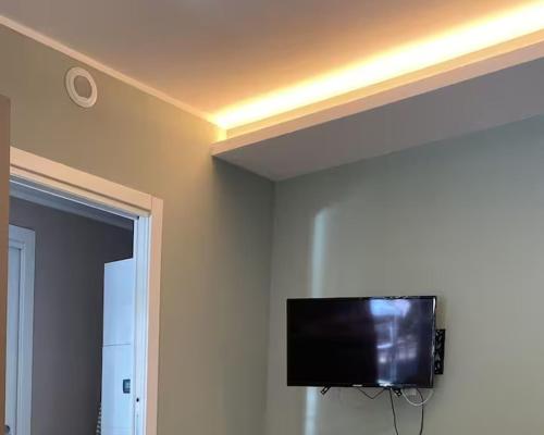 a flat screen tv on the corner of a room at Appartamento vicino a Ospedale, Duomo, ENI - MB in San Giuliano Milanese