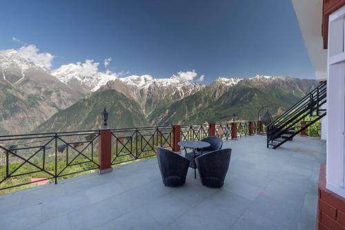 a balcony with chairs and a view of mountains at Echor - The Alpine Crest in Kalpa