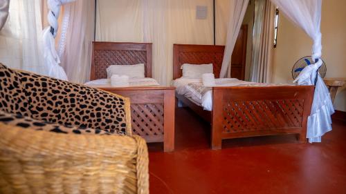 a room with two beds and a mirror at Vijiji Center Lodge and Safari in Arusha