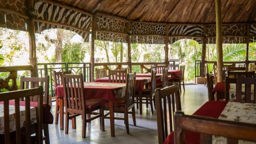 a restaurant with tables and chairs with red table cloth at Vijiji Center Lodge and Safari in Arusha