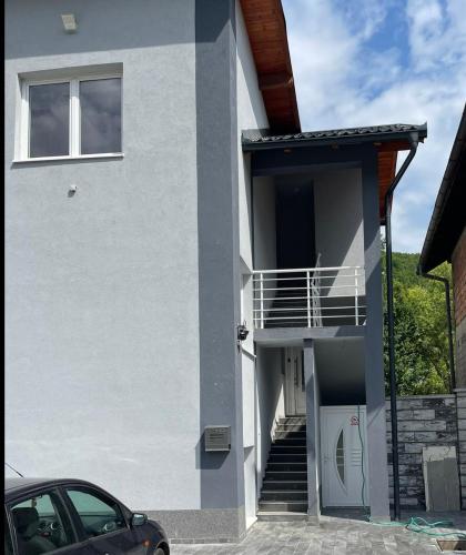 a white house with a balcony and a car at Crater H in Kukrike
