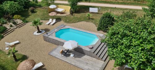 une vue aérienne d'une piscine dans un jardin dans l'établissement LA GARE DE L'ART - Gästehaus im ehemaligen Bahnhof, à Rouairoux