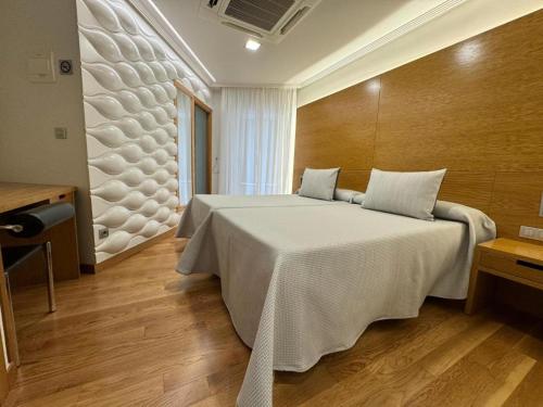 a bedroom with a large white bed in a room at Hotel Lino in Vigo