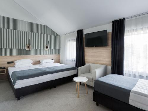 a hotel room with two beds and a tv at City Park Hotel in Skopje