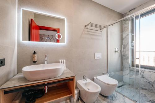 a bathroom with a sink and a toilet and a shower at Ermes Luxury Hotel in Durrës