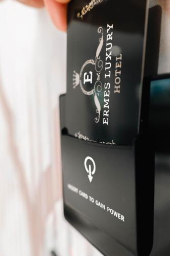 a person holding up a cell phone with a box at Ermes Luxury Hotel in Durrës