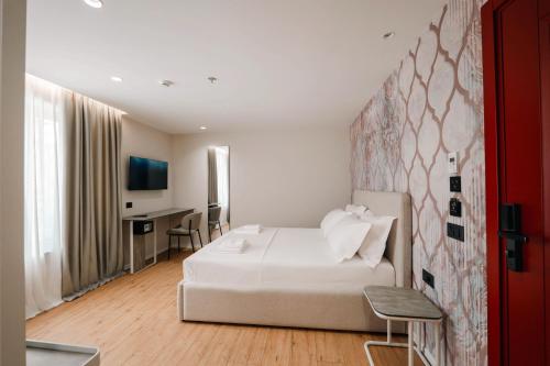 a hotel room with a bed and a desk at Ermes Luxury Hotel in Durrës