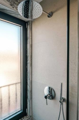 a shower in a bathroom with a window at Ermes Luxury Hotel in Durrës