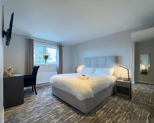 a bedroom with a bed and a desk and a window at Golf Links House in Newcastle