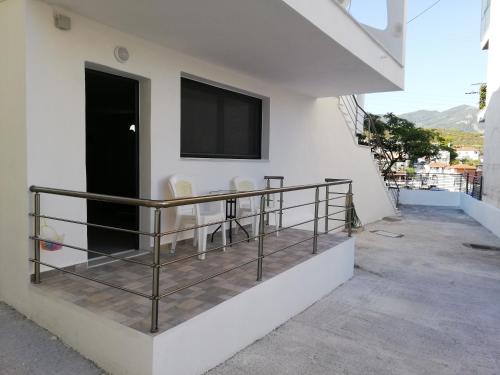 a balcony with chairs and a television on a building at Ground-Floor Studio Apartment in Neos Marmaras